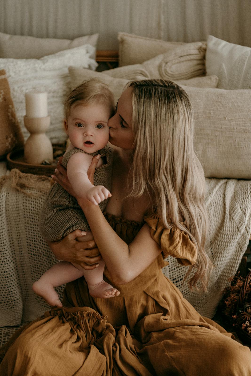 A mother lovingly holds her baby, creating a cozy and warm family portrait.